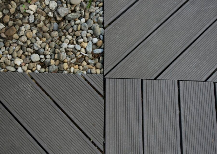 Sample tiles showing river pebbles beside gray composite deck boards laid in different patterns